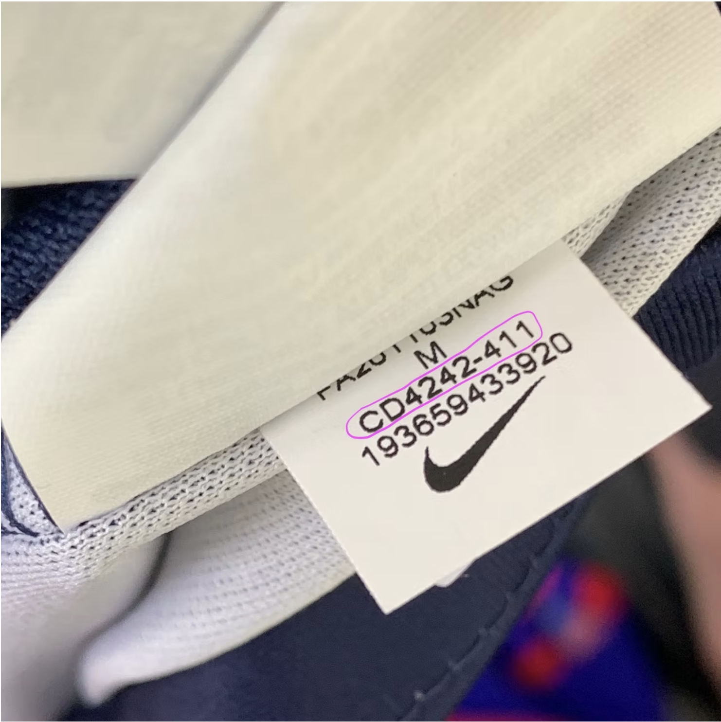 Nike shirt turned inside out with the care tag stitched into the lower-left hem seam